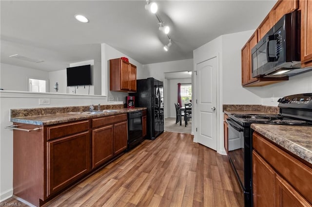 203 Cross Country Chase, Stokesdale, NC 27357 - kitchen with brown cabinetry, wood finished floors, dark countertops, a sink, and black appliances