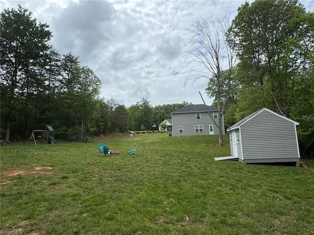 view of yard with a storage shed, an outdoor structure, and a playground