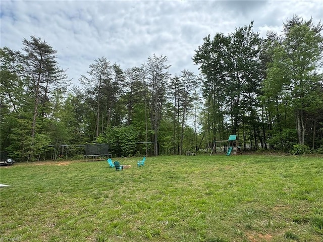 view of yard featuring a trampoline and a playground