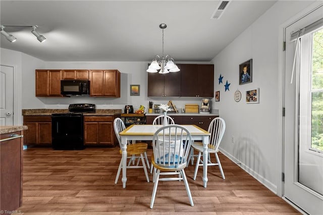 203 Cross Country Chase, Stokesdale, NC 27357 - kitchen featuring light wood-style floors, decorative light fixtures, black appliances, and a chandelier
