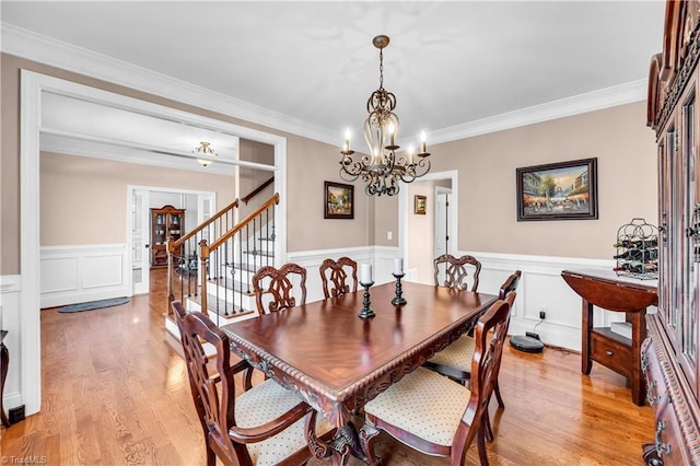 dining room with light hardwood / wood-style floors, a notable chandelier, and ornamental molding