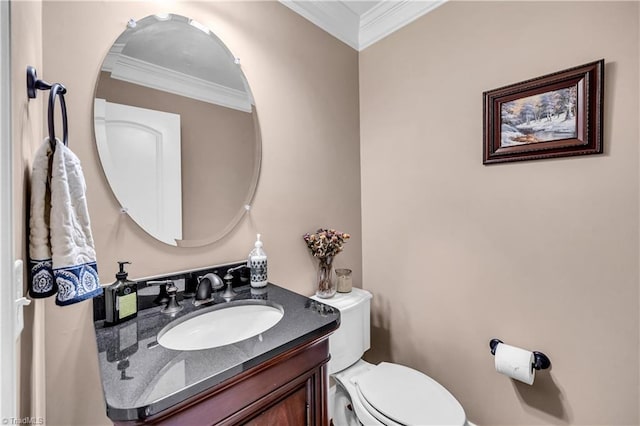 bathroom with toilet, vanity, and ornamental molding