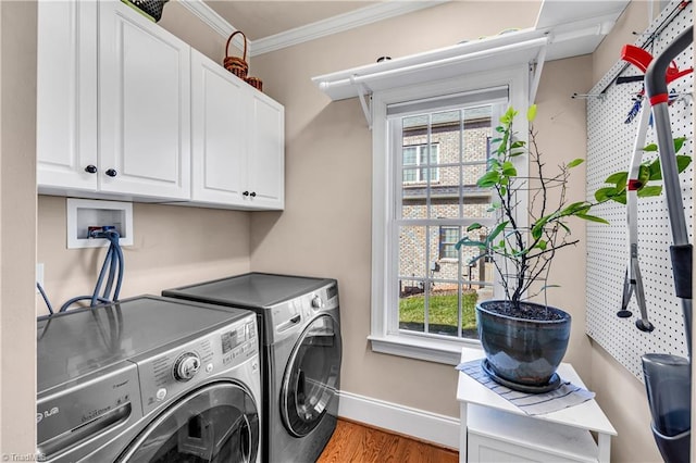 clothes washing area with separate washer and dryer, crown molding, cabinets, and a wealth of natural light