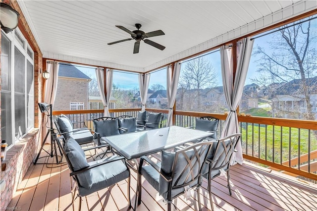 sunroom featuring ceiling fan and a mountain view