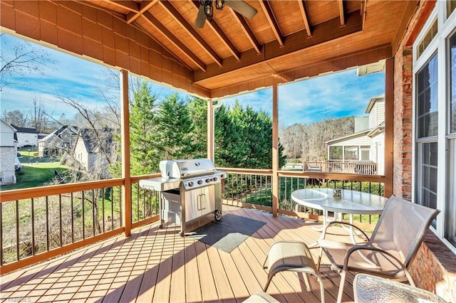 wooden deck with area for grilling and ceiling fan