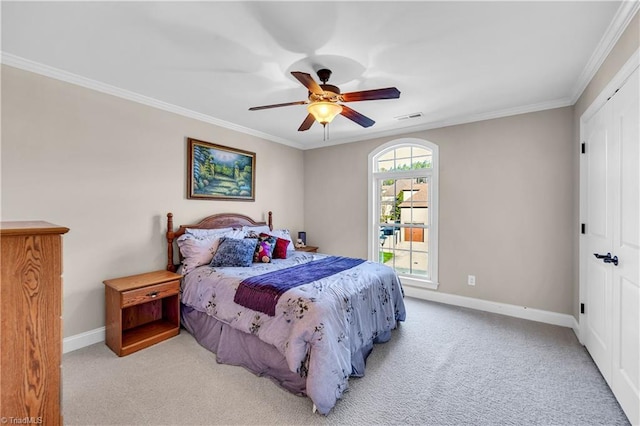 carpeted bedroom with ceiling fan, crown molding, and a closet