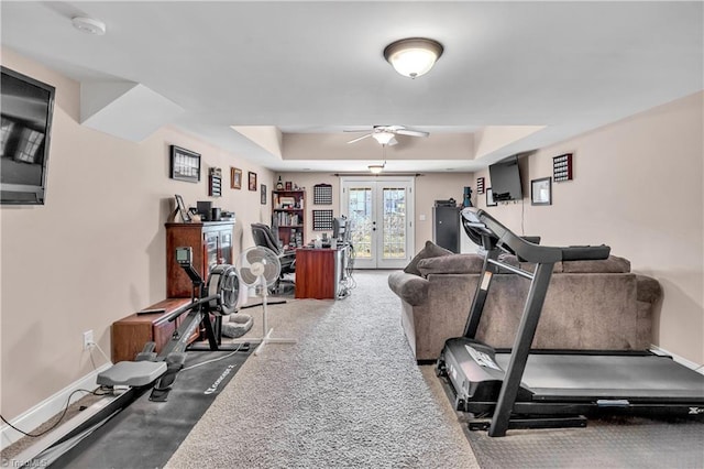 workout room with carpet, ceiling fan, a raised ceiling, and french doors