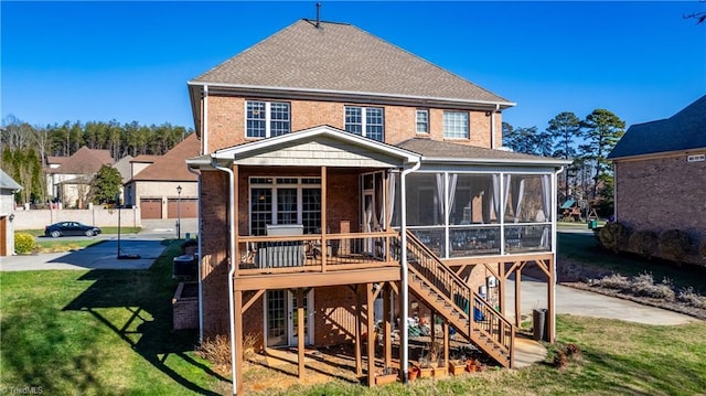 back of house with a lawn and a sunroom