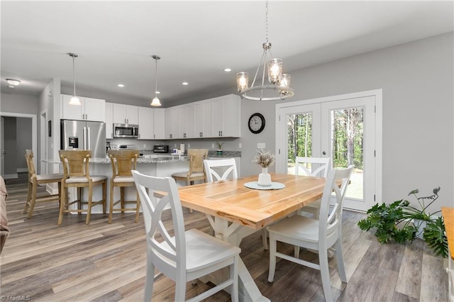 dining space featuring an inviting chandelier, french doors, recessed lighting, and light wood-style flooring