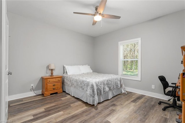 bedroom featuring baseboards, ceiling fan, and wood finished floors