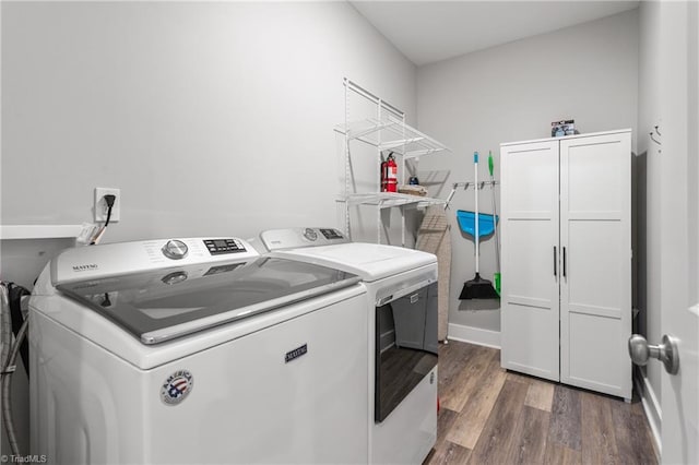 washroom featuring cabinet space, independent washer and dryer, and wood finished floors