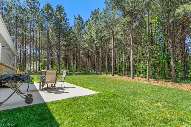 view of yard with a view of trees and a patio area