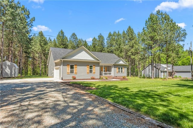 view of front of house with a garage, concrete driveway, a shed, and a front yard