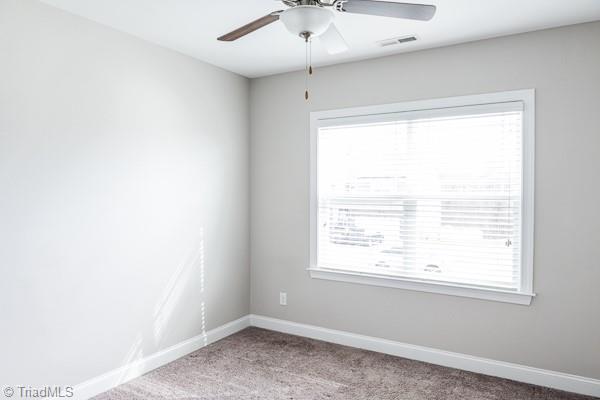 carpeted empty room featuring ceiling fan