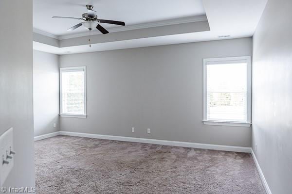 carpeted empty room featuring crown molding, ceiling fan, and a tray ceiling