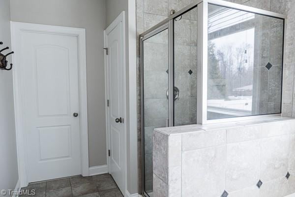 bathroom with tile patterned floors and a shower with shower door