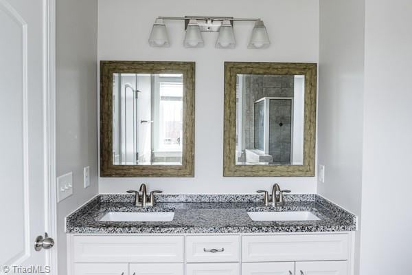 bathroom with vanity and a shower with door