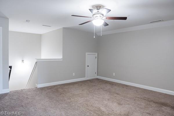 carpeted spare room featuring ceiling fan