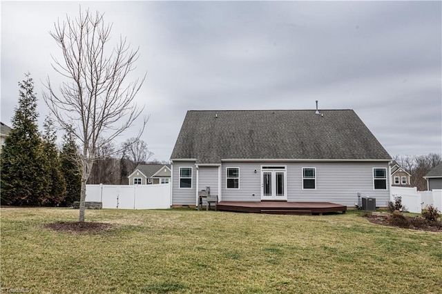 back of property with central AC unit, a yard, a deck, and french doors