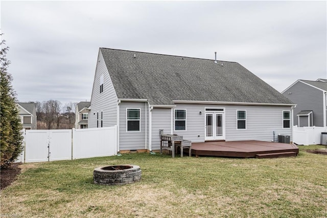 back of house featuring a wooden deck, a yard, and an outdoor fire pit