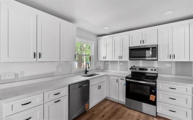 1710 Scarborough Rd, High Point, NC 27265 - kitchen with appliances with stainless steel finishes, white cabinets, recessed lighting, dark wood-style flooring, and light stone countertops