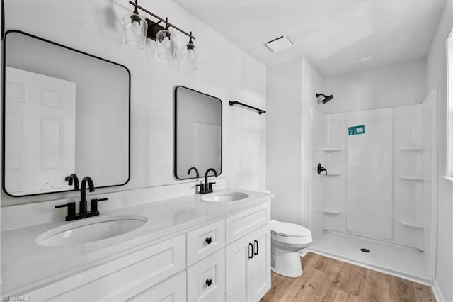1710 Scarborough Rd, High Point, NC 27265 - bathroom featuring a shower, double vanity, and wood finished floors