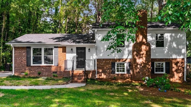 1710 Scarborough Rd, High Point, NC 27265 - tri-level home featuring a chimney, a front yard, and brick siding