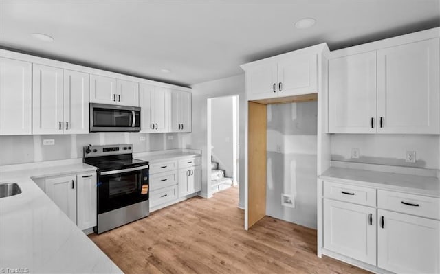 1710 Scarborough Rd, High Point, NC 27265 - kitchen featuring stainless steel appliances, white cabinetry, light wood-style flooring, and recessed lighting