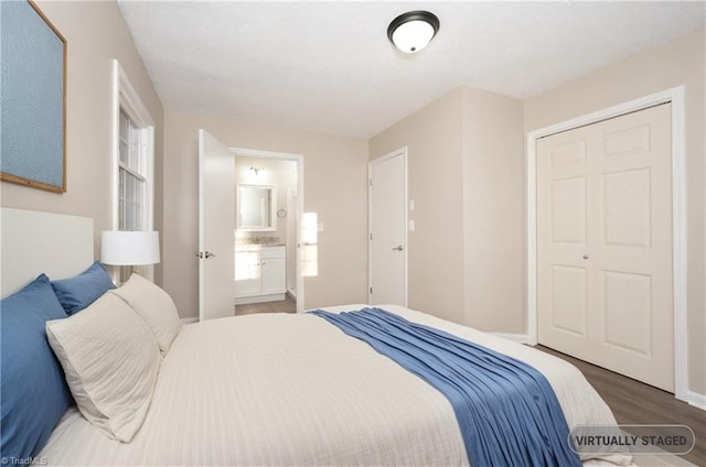 bedroom with dark hardwood / wood-style floors, connected bathroom, and a closet