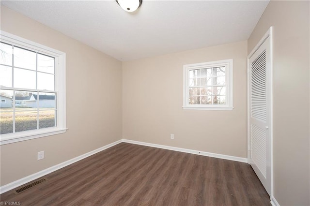 unfurnished bedroom featuring dark hardwood / wood-style floors and a closet