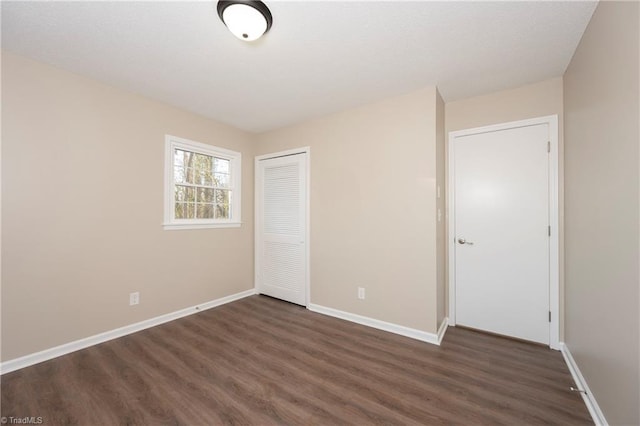 unfurnished bedroom with a closet and dark hardwood / wood-style floors