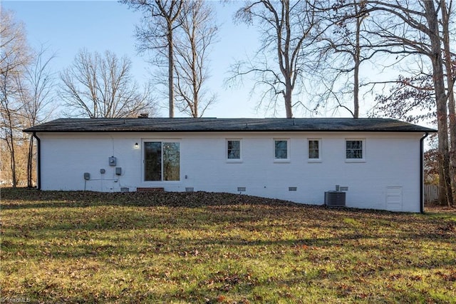 rear view of property with a yard and central air condition unit