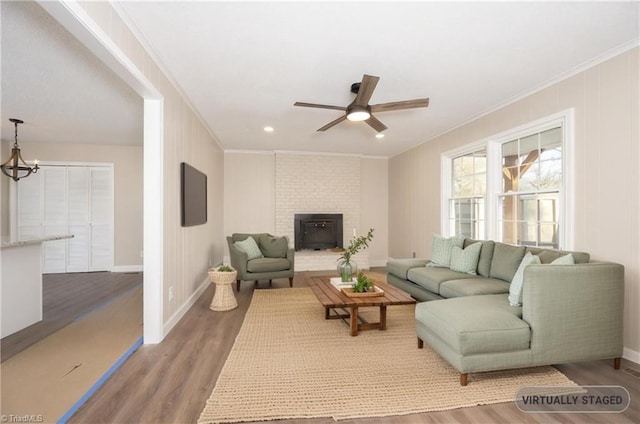 living room featuring hardwood / wood-style floors, ceiling fan, and crown molding