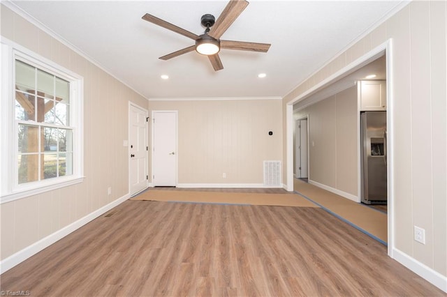 unfurnished room featuring ceiling fan, light wood-type flooring, and ornamental molding