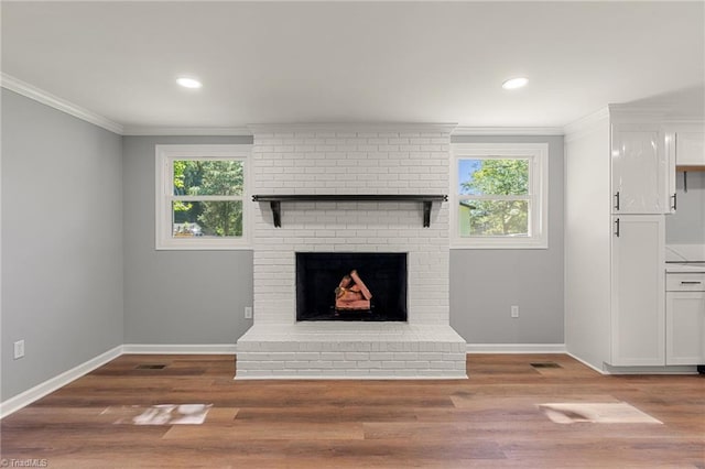 5403 Southmont Dr, Julian, NC 27283 - unfurnished living room featuring crown molding, plenty of natural light, wood finished floors, a fireplace, and recessed lighting