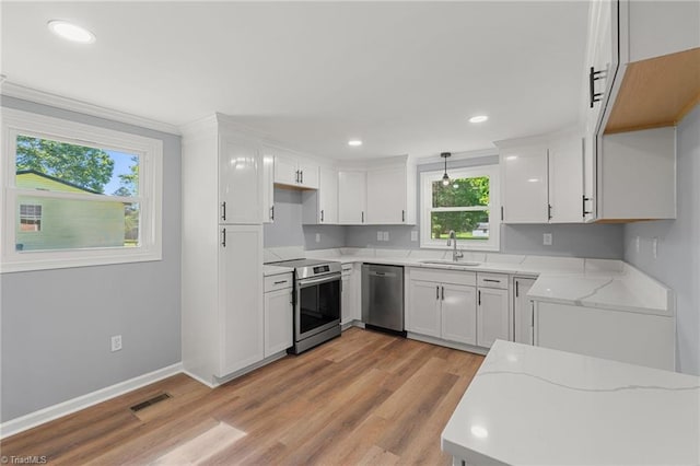 5403 Southmont Dr, Julian, NC 27283 - kitchen featuring stainless steel appliances, light stone countertops, white cabinets, light wood-style floors, and recessed lighting