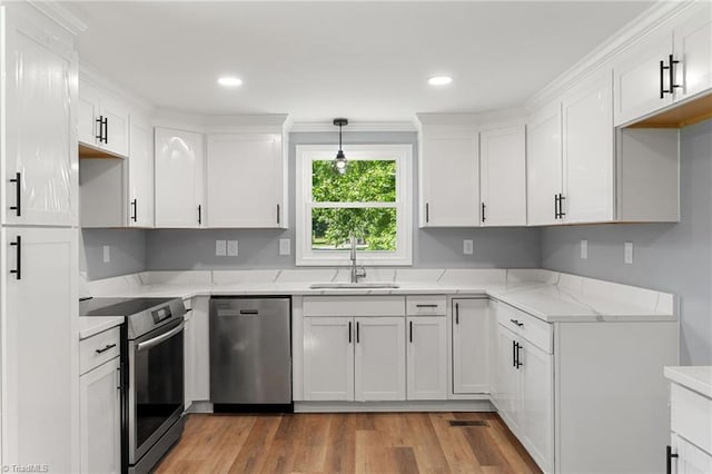 5403 Southmont Dr, Julian, NC 27283 - kitchen featuring stainless steel appliances, light wood-style floors, white cabinets, light stone countertops, and recessed lighting