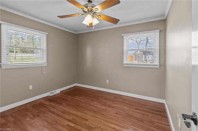 unfurnished room with baseboards, visible vents, crown molding, and a healthy amount of sunlight