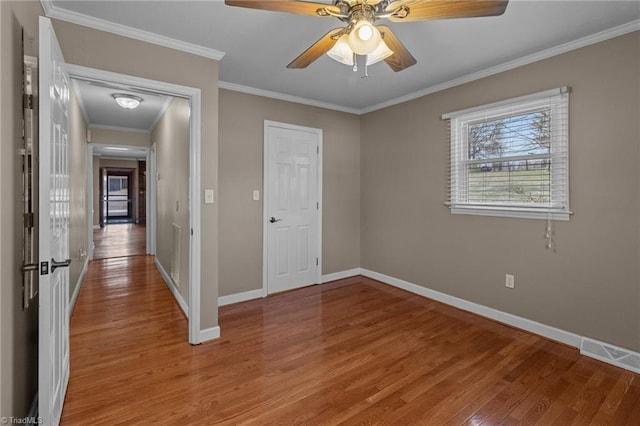 unfurnished bedroom with light wood finished floors, baseboards, visible vents, ceiling fan, and ornamental molding