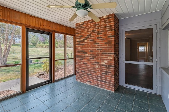 unfurnished sunroom featuring ceiling fan
