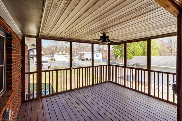unfurnished sunroom featuring a ceiling fan