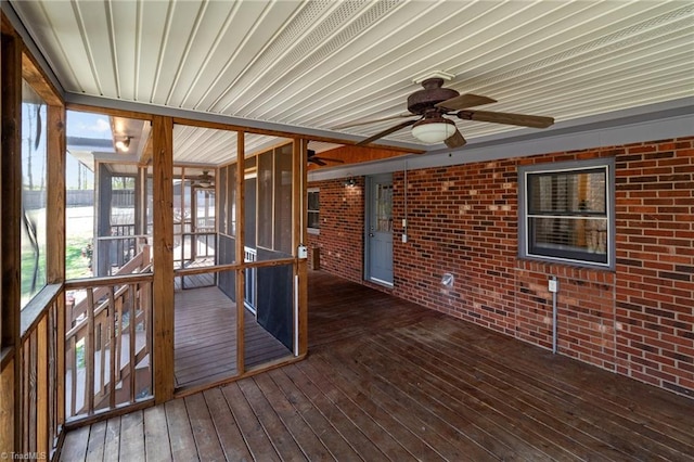 unfurnished sunroom featuring a ceiling fan