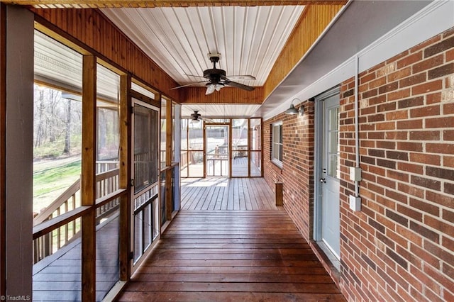 unfurnished sunroom featuring a ceiling fan
