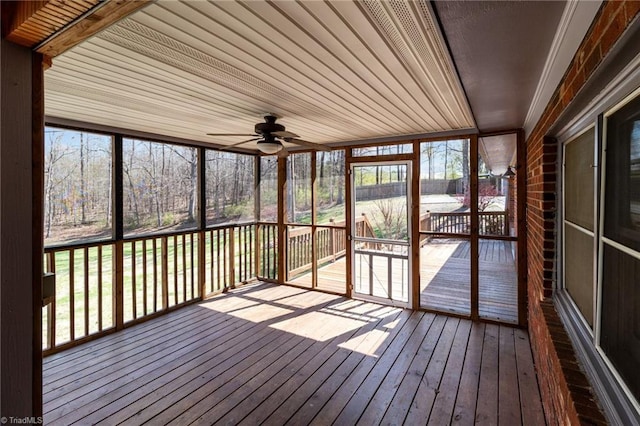 unfurnished sunroom featuring ceiling fan