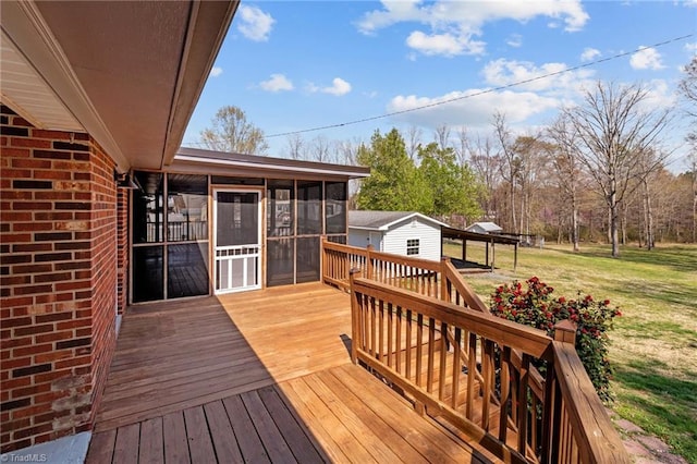 wooden terrace with a sunroom, an outdoor structure, and a yard
