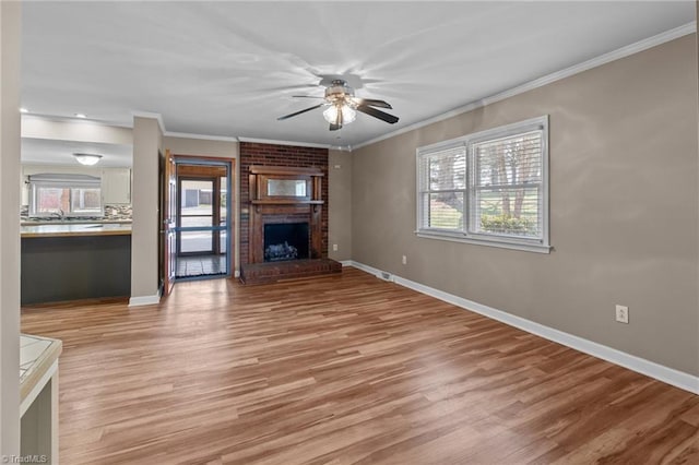 unfurnished living room with baseboards, light wood-type flooring, ornamental molding, and a ceiling fan