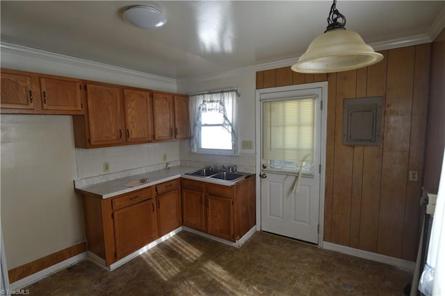 kitchen with electric panel, sink, hanging light fixtures, wooden walls, and ornamental molding