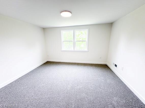 empty room with carpet and baseboards