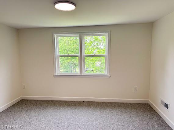 empty room with carpet and baseboards