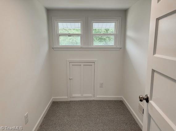 spare room with healthy amount of natural light, carpet, and baseboards